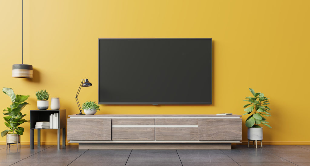 TV on cabinet in modern living room on yellow wall background