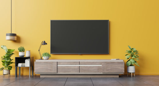 TV on cabinet in modern living room on yellow wall background